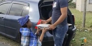 VIDEO: A woman kneels down when giving her partner food with a tray