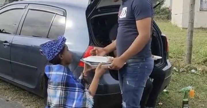 VIDEO: A woman kneels down when giving her partner food with a tray