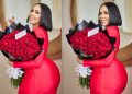 Brown Mbombo Delights Fans with Glamorous Red Outfit and Rose Bouquet